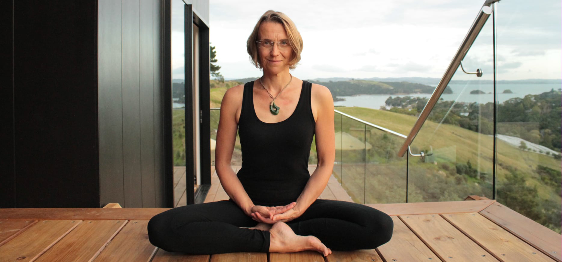 Woman sitting in a yoga pose on a deck